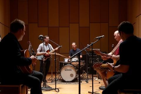 Studio session with musicians playing instruments in a live room.